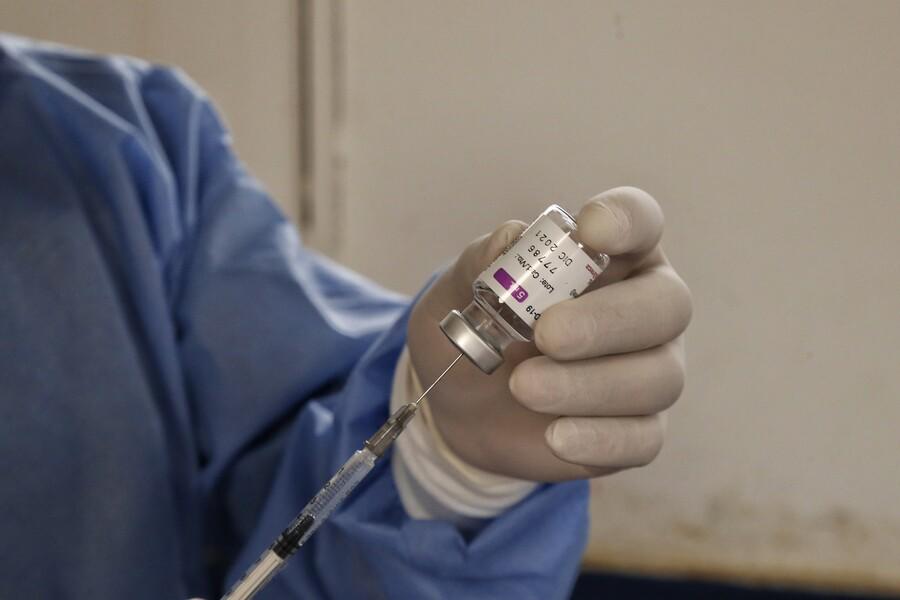 Un especialista de la salud sacando por medio de la aguja un medicamento. FOTO: Colrpensa