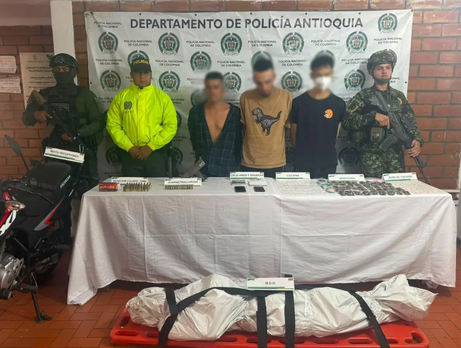 En la imagen, unos de los detenidos en el operativo de Salgar junto al cuerpo del presunto delincuente abatido. FOTO: Cortesía