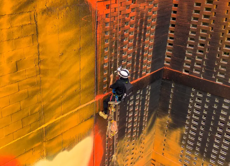 Así trabaja Daniel Quiceno, @perrograff, pintando este edificio en El Poblado. FOTO Camilo Suárez