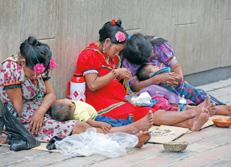 Indígenas piden dinero en compañía de sus hijos. 