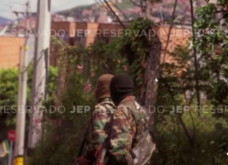 La foto que expuso la JEP durante la audiencia, muestra a dos hombres con camuflado militar, capuchas y fusiles terciados. FOTO: CORTESÍA JEP.
