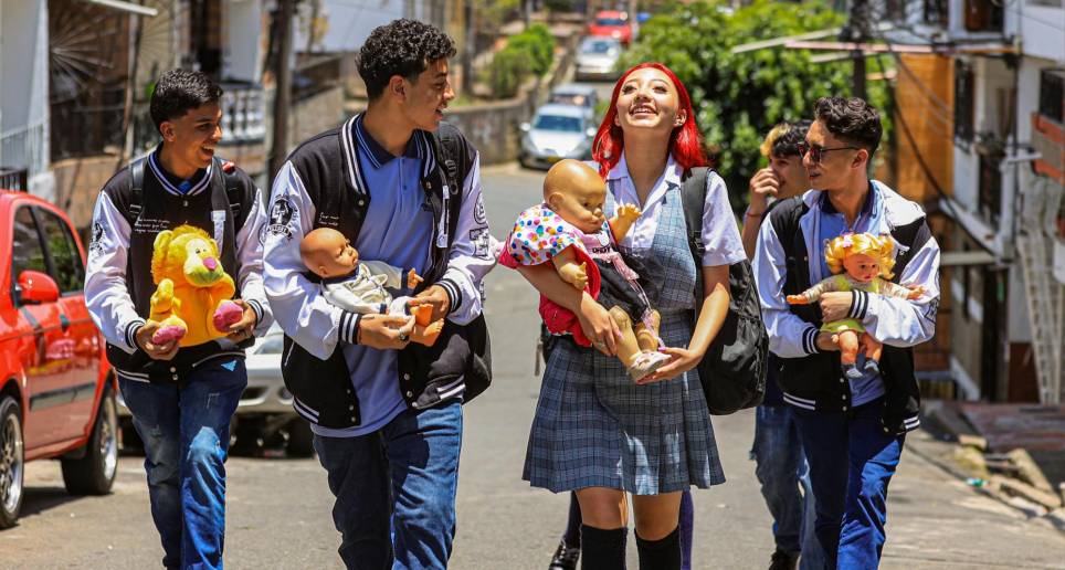 Alumnos del Presbítero Camilo Torres caminan por las calles de Campo Valdés junto a sus “bebés”. FOTO Manuel Saldarriaga