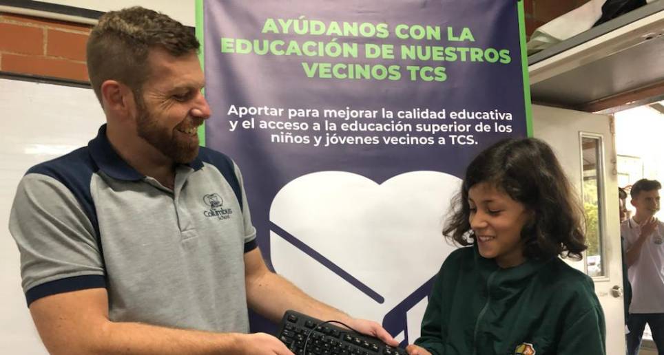 El profesor David Murphy de la institución The Columbus School entregando una donación de computadores en la I.E. Las Palmas, de Envigado. Foto: Cortesía