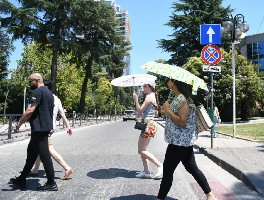 Las personas van con sombrillas debido al intenso calor. FOTO: AFP