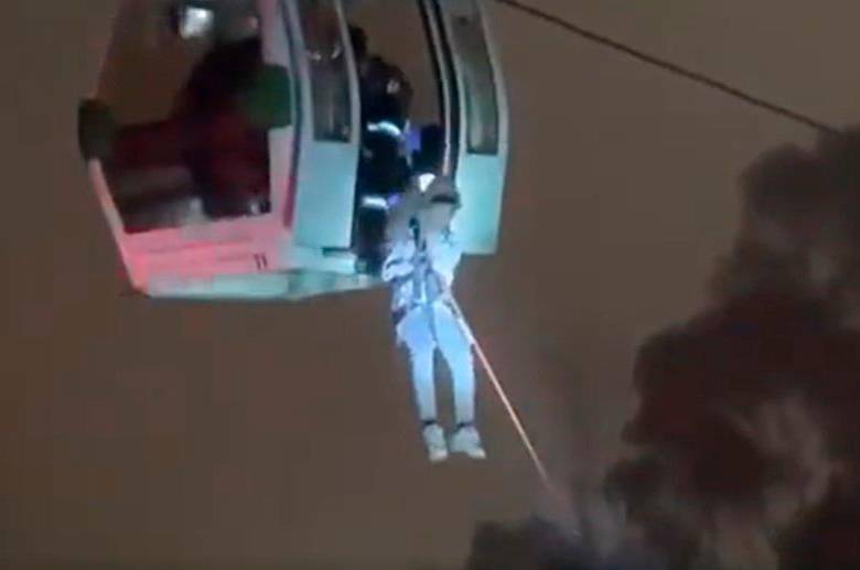 Las personas descendieron de las cabinas por cuerdas con la ayuda de rescatistas que iluminaban la operación con linternas, pues la operación se llevo a cabo en la madrugada de este viernes. FOTO: CAPTURA DE VIDEO
