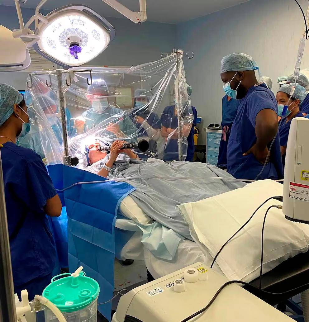 Durante la cirugía en el King’s College Hospital de Londres, Denise Bacon permaneció despierta y tocó el clarinete para que los médicos evaluaran en tiempo real la precisión de la estimulación cerebral profunda. FOTO Tomada de Instagram @kingscollegehospital 