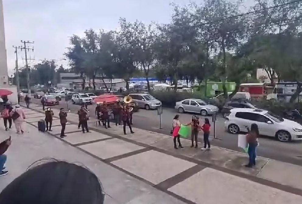 A la izquierda, se puede ver a la banda tocando música en el momento de la salida de la mujer de la Registraduría Civil mexicana. FOTO: CAPTURA DE VIDEO