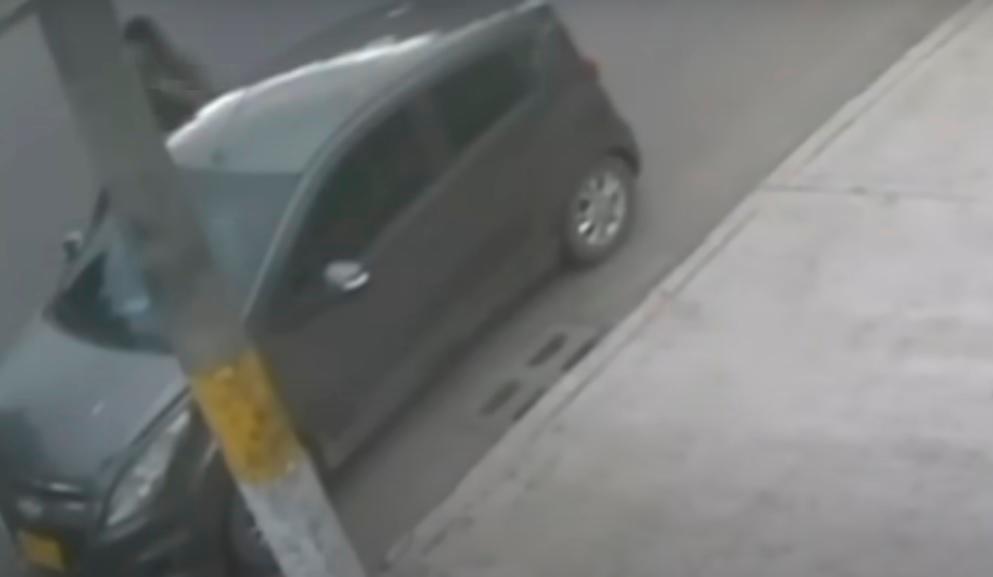 Una cámara captó el vehículo en el que presuntamente iban Carlos Mora y el sicario adolescente, quien se ve saliendo de su interior. FOTO: CORTESÍA IMÁGENES NOTICIAS CARACOL.