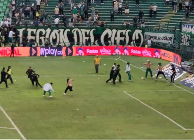 La Policía intervino para controlar a los hinchas del Cali que ingresaron al terreno de juego tras el final del partido en el cuadro azucarero y Bucaramanga. FOTO: CAPTURA VIDEO @AndresfelipeOK_
