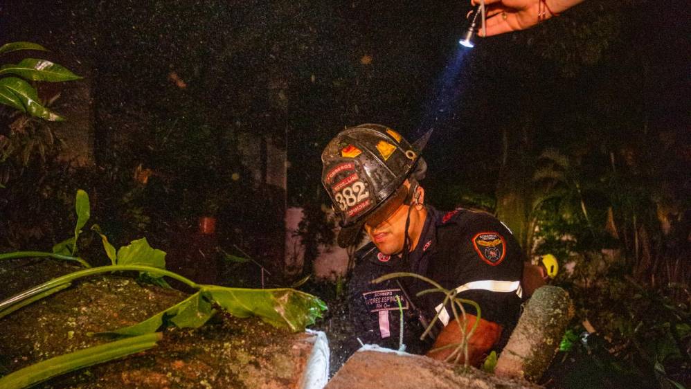Incluso alumbrando con linternas los bomberos trabajan para restablecer el paso. FOTO: CARLOS VELÁSQUEZ