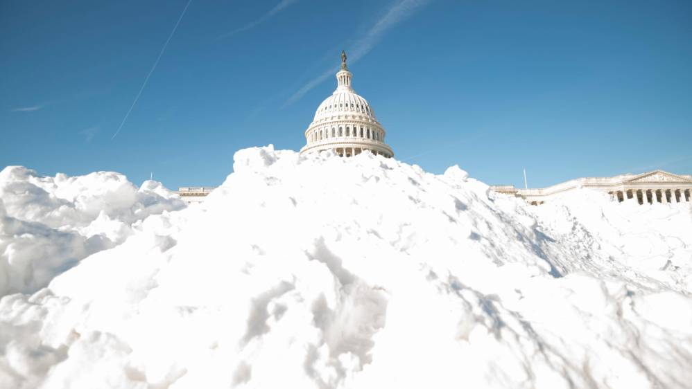 La cúpula del Capitolio de los EE. UU. Aparece detrás de uno de los muchos montículos de nieve. FOTO: Getty
