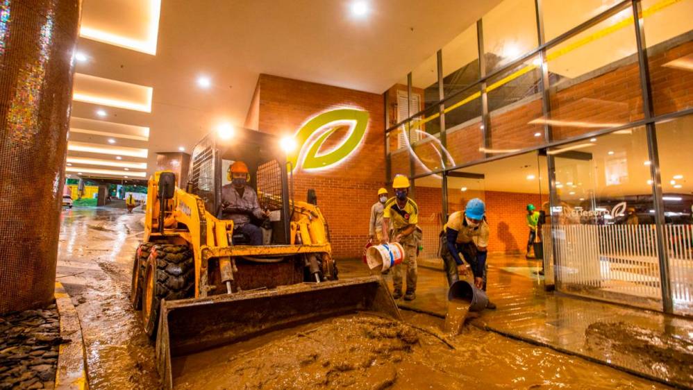 El centro comercial El Tesoro fue uno de los más afectados, los trabajadores de los almacenes trataron de sacar el agua y el lodo que los inundó. FOTO CARLOS VELASQUEZ