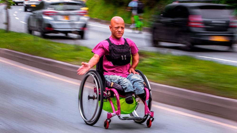 Desciende rápidamente en su silla de ruedas por las calles, desafiando la vida. Foto : Camilo Suárez Echeverry. 