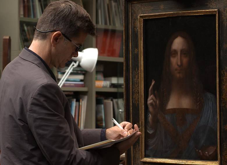 Larry Keith, director de conservación de la Galería Nacional de Londres, revisa Salvator Mundi de Leonardo Davinci, la pintura más cara del mundo (USD $ 450 millones). FOTO exhibition on screen