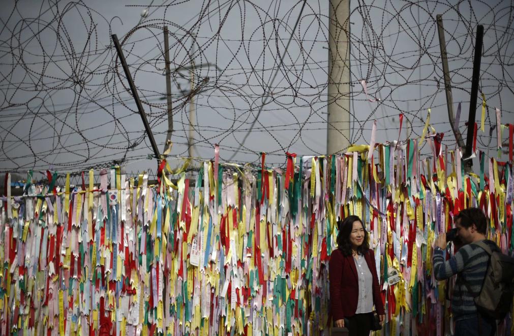 Otra parte de la cerca de alambre de púas aparece decorada con las banderas nacionales de Corea del Norte y Corea del Sur, cerca de la zona desmilitarizada, una franja de seguridad que protege el límite territorial de tregua entre las repúblicas coreanas, establecido en 1953. Mide 4 km de ancho y 238 km de longitud. FOTO REUTERS