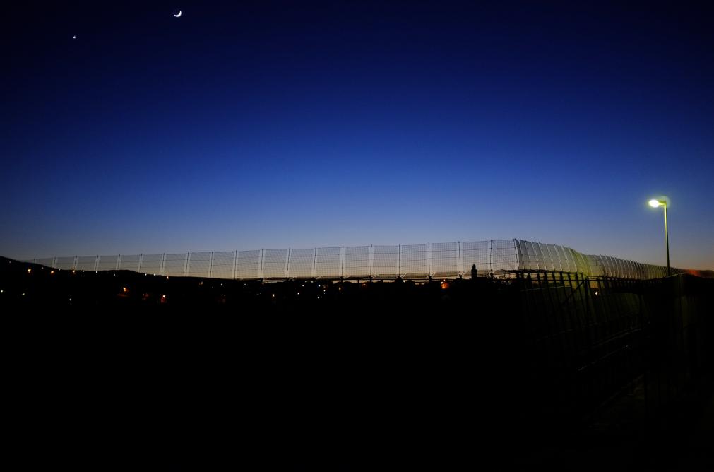 La luna se aprecia por encima de la barrera que separa a Marruecos de España, en esta foto tomada el 3 de diciembre de 2013. FOTO REUTERS