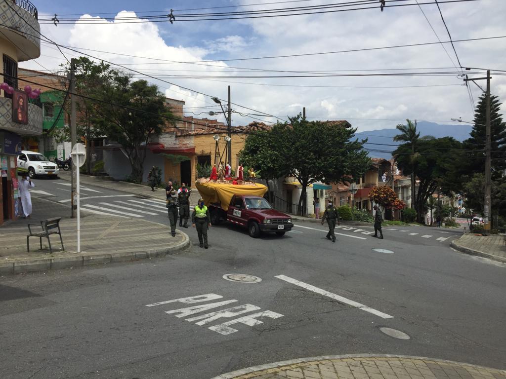 En el Barrio La Milagrosa, de la comuna 9 de Medellín, la iglesia organizó una procesión solitaria donde imparte la palabra acompañada de la policía. Los feligreses salen a los balcones al paso de la procesión. Foto: Edwin Bustamante.
