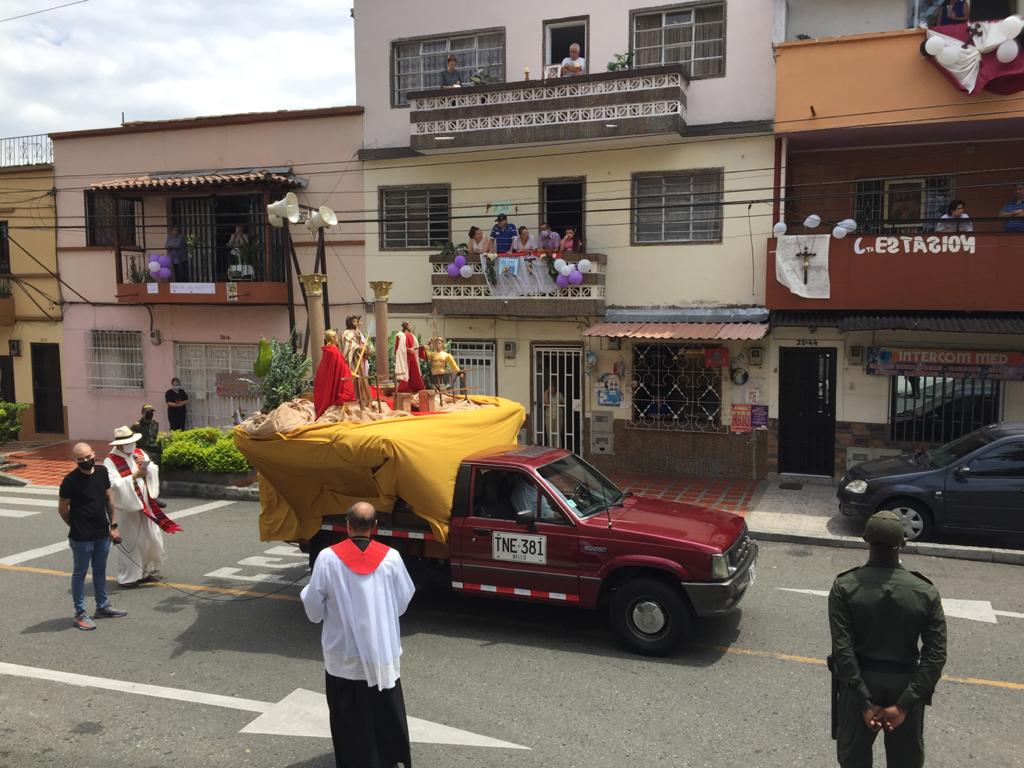 En el Barrio La Milagrosa, de la comuna 9 de Medellín, la iglesia organizó una procesión solitaria donde imparte la palabra acompañada de la policía. Los feligreses salen a los balcones al paso de la procesión. Foto: Edwin Bustamante.