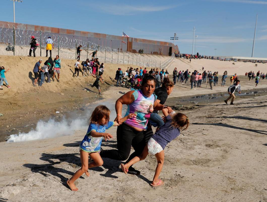 Una familia trata de protegerse de los gases lacrimógenos en Tijuana, México. Noviembre. Foto: Reuters.
