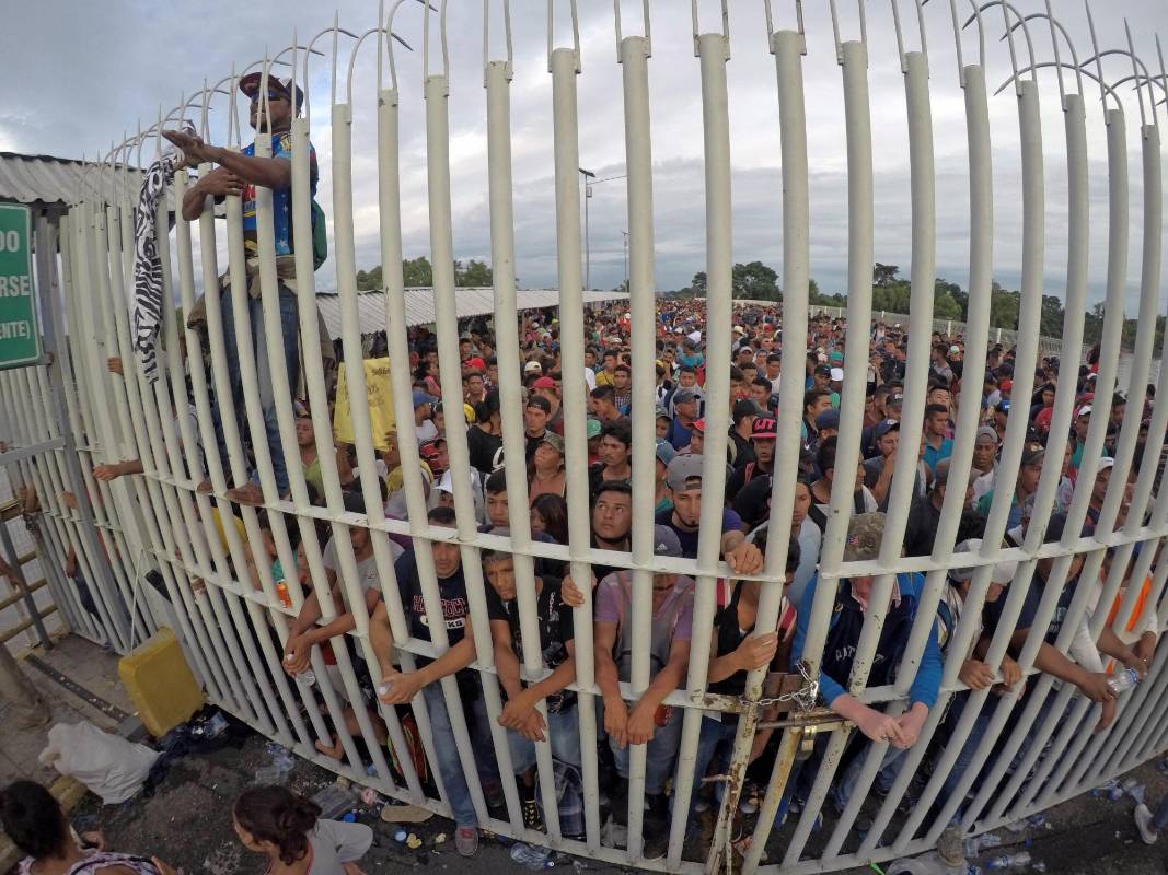 Miles de migrantes hondureños, que salieron en caravana de su país con destino a Estados Unidos, viven una tensa espera en el puente fronterizo entre México y Guatemala. EFE