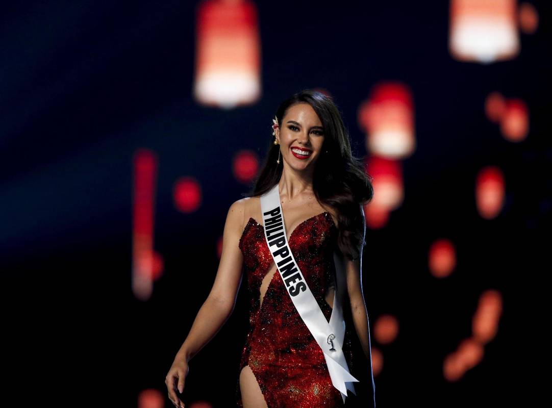 Al escuchar su nombre, Gray, que lucía un largo vestido de noche rojo y brillante -inspirado en el volcán Mayón, vinculado a sus raíces filipinas- que mostraba la pierna derecha, se fundió en un abrazo con la sudafricana Tamaryn Green, primera dama de honor. FOTO EFE
