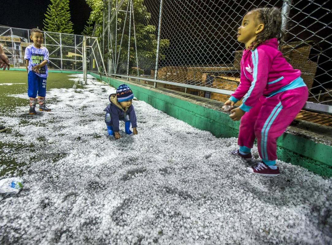Los niños fueron abrigados por sus madres para que disfrutaran del granizo acumulado. Foto Juan Antonio Sánchez Ocampo