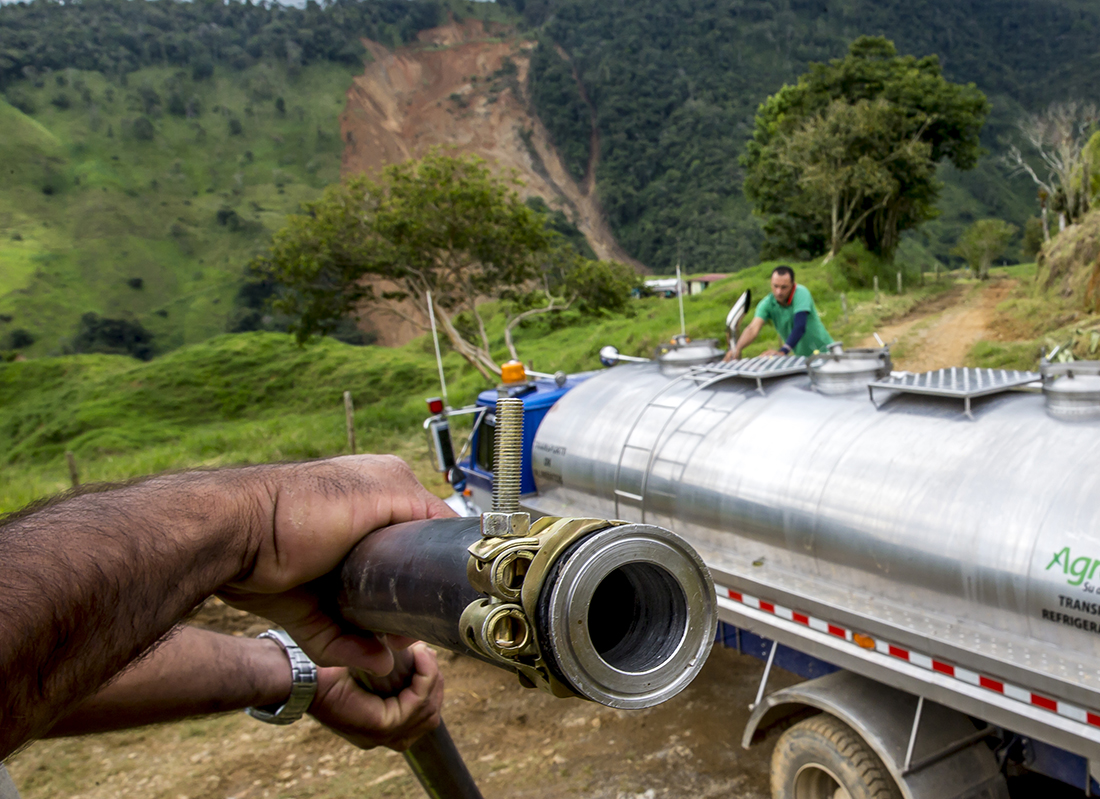 Los habitantes encontraron la solución para sacar la leche. Extendieron 3,000 metros de mangueras y ayudados con motobombas están sacando la leche que tenían represada y a punto de perderse. Foto Juan Antonio Sánchez Ocampo