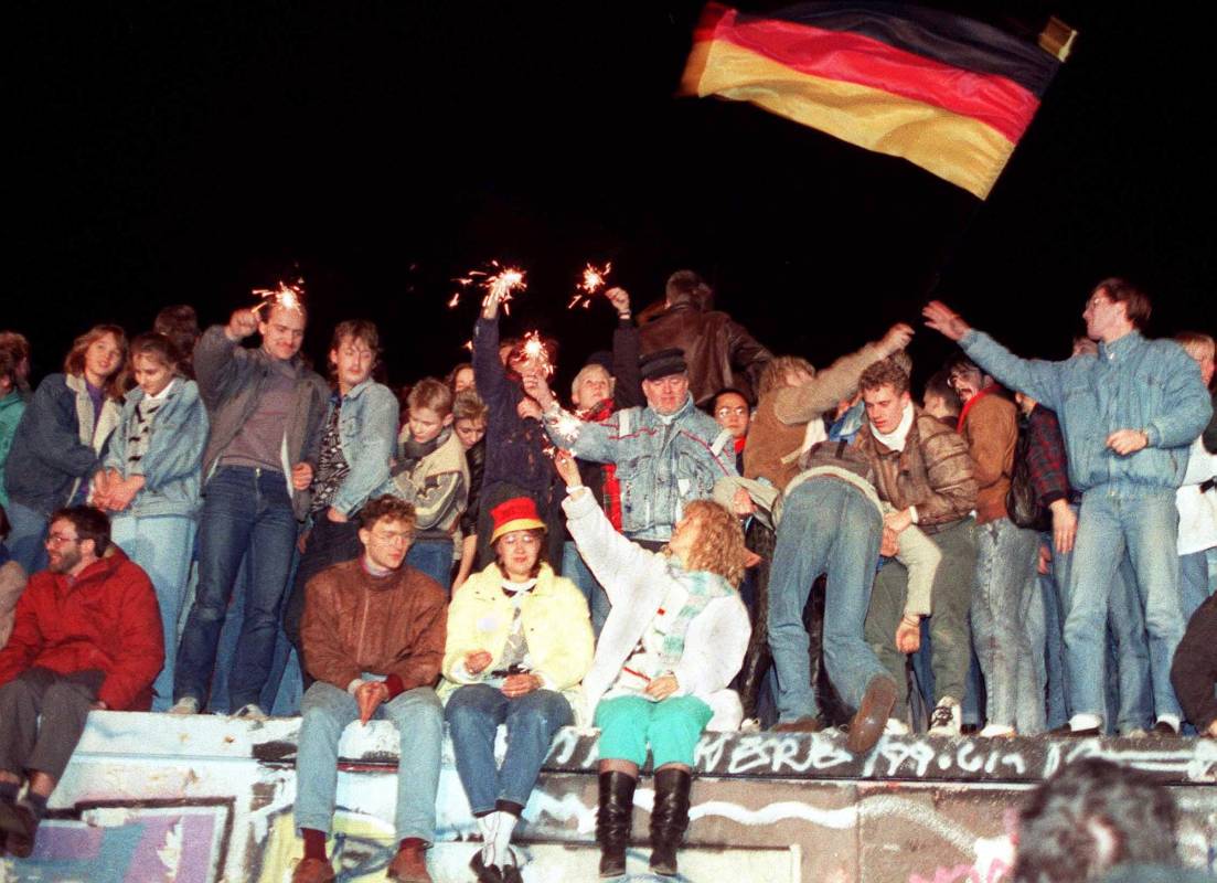 Jóvenes berlineses orientales celebran en lo alto del muro de Berlín. Foto de archivo tomada el 11 de noviembre de 1989. FOTO AFP