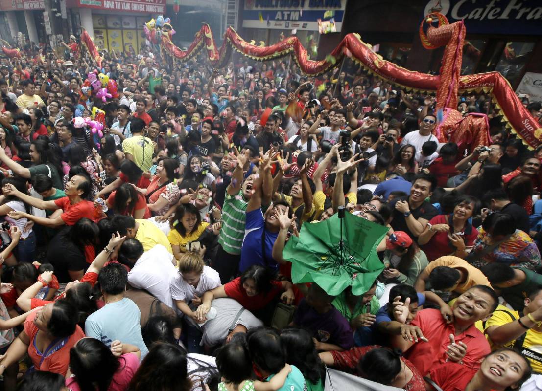 Al son de la música y el ambiente callejero, cientos de bailarines desfilan estos días por las calles chinas para dar vida a la “danza del león”. FOTO AP