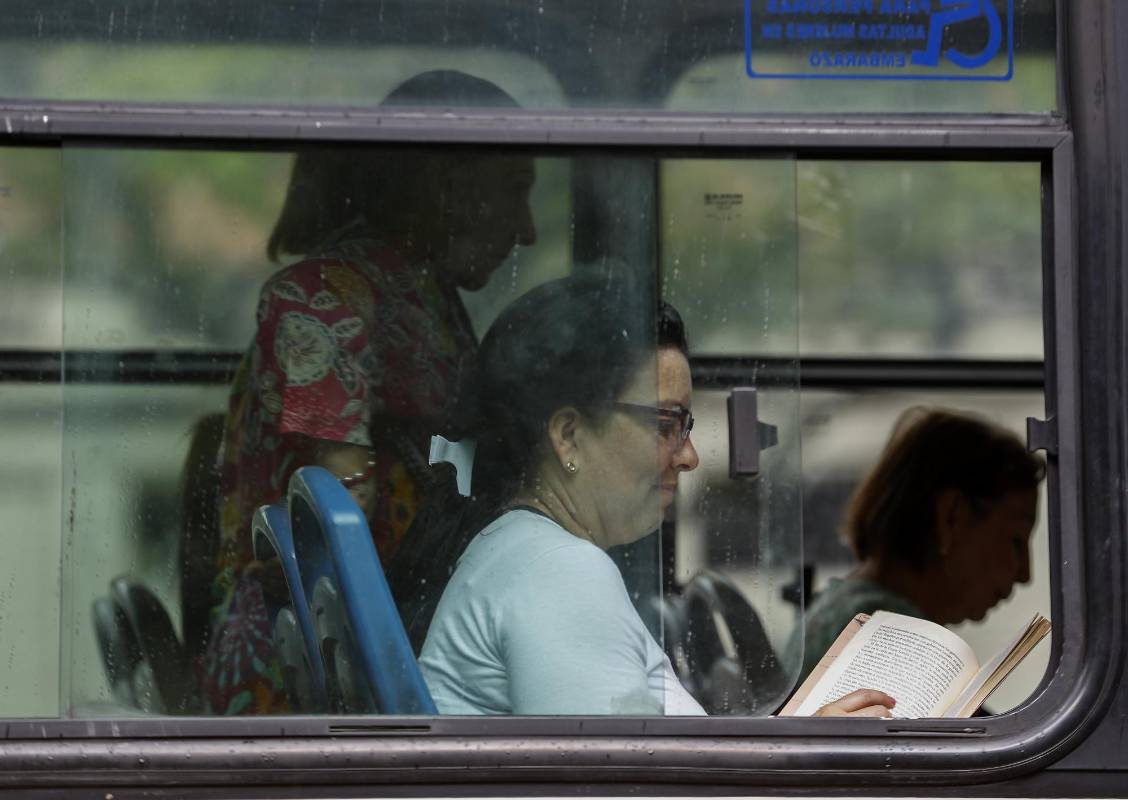 En medio de la agitada rutina de la ciudad, lectores espontáneos aprovechan un momento de calma para leer un buen libro. Foto: Manuel Saldarriaga.