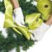 2. El moño - Con la cinta raso de color verde elaborar un moño y amarrar con las mismas ramas de la guirnalda.