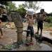 AP - Muchachos de Bhubaneswar, India, se bañan con agua de una bomba de mano.