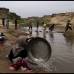 AP - Niñas pakistaníes lavan su ropa en un arroyo contaminado en un barrio pobre en las afueras de Islamabad, Pakistán.