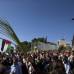 Reuters - Una cat&#243;lica tiene una hoja de palma con una bandera palestina durante la procesi&#243;n de Domingo de Ramos en el Monte de los Olivos en Jerusal&#233;n.