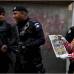 AP - Un oficial de polic&#237;a sonr&#237;e mientras un payaso sostiene un peri&#243;dico que representa una escena del crimen y dice en tono de broma: &quot;La polic&#237;a, siempre en las noticias&quot;.