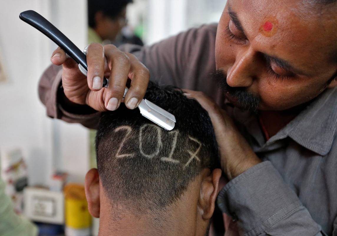 Aunque los indios tienen su propio año nuevo, algunos han adoptado las costumbres Occidentales. Este hombre de Ahmedabad, India, decidió marcarse el 2017 en la cabeza. FOTO Reuters