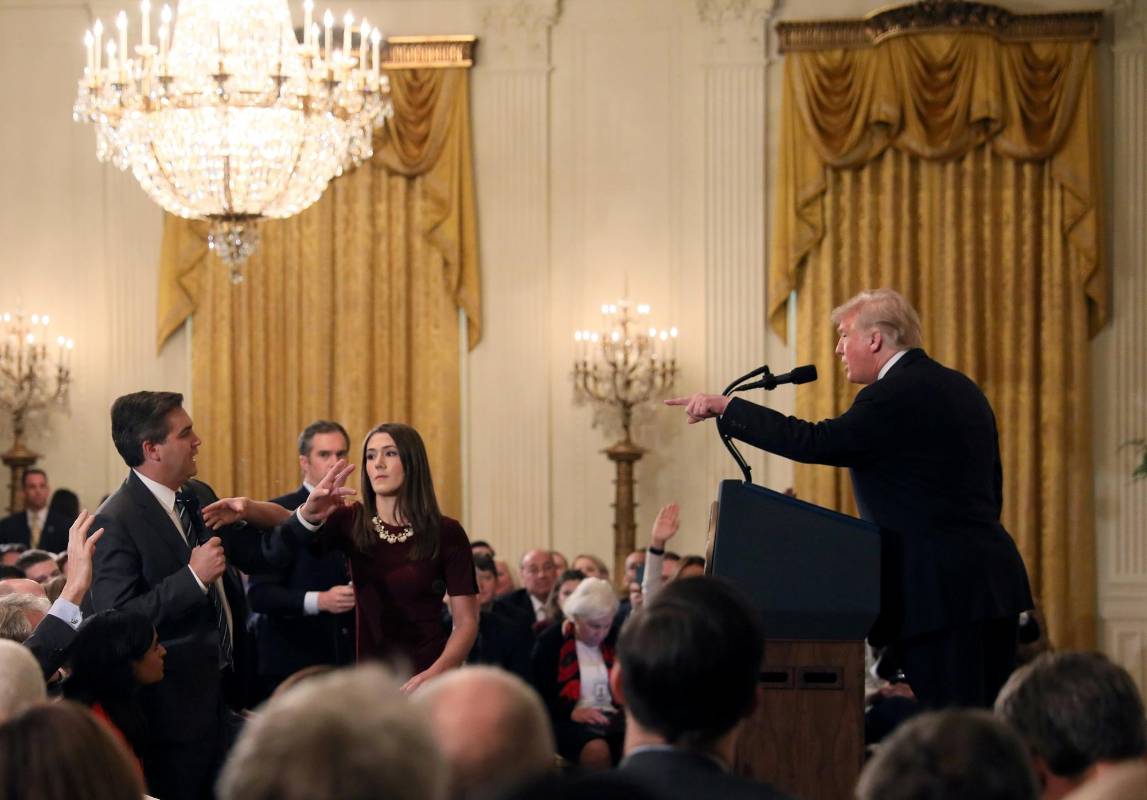 Un miembro del personal de la Casa Blanca busca el micrófono que tiene Jim Acosta de la CNN cuando cuestiona al presidente de los Estados Unidos, Donald Trump, durante una conferencia de prensa luego de las elecciones parlamentarias del Congreso de los Estados Unidos, en la Casa Blanca en Washington, EE. UU., El 7 de noviembre de 2018. REUTERS / Jonathan Ernst 