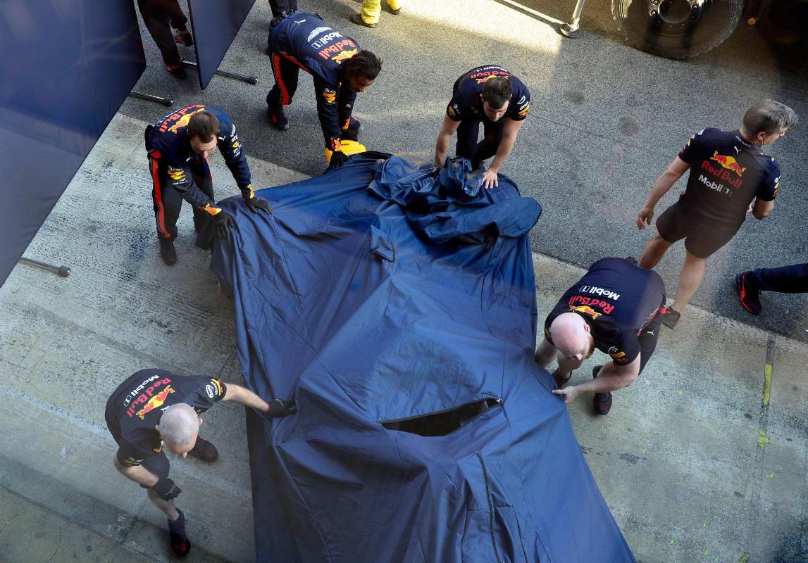 Los mecánicos cubren el auto del piloto Francés de Red Bull Racing, Pierre Gasly, después de estrellarse durante las pruebas para la nueva temporada del Gran Premio de Fórmula Uno en el circuito de Cataluña. Foto: AFP