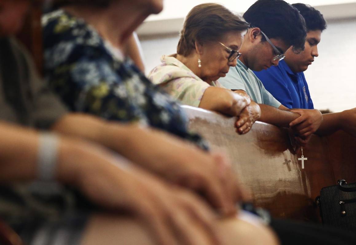 Personas asisten a una vigilia de oración en el templo católico Santísimo Sacramento. Oran por las víctimas del tiroteo en El Paso. FOTO: AFP.