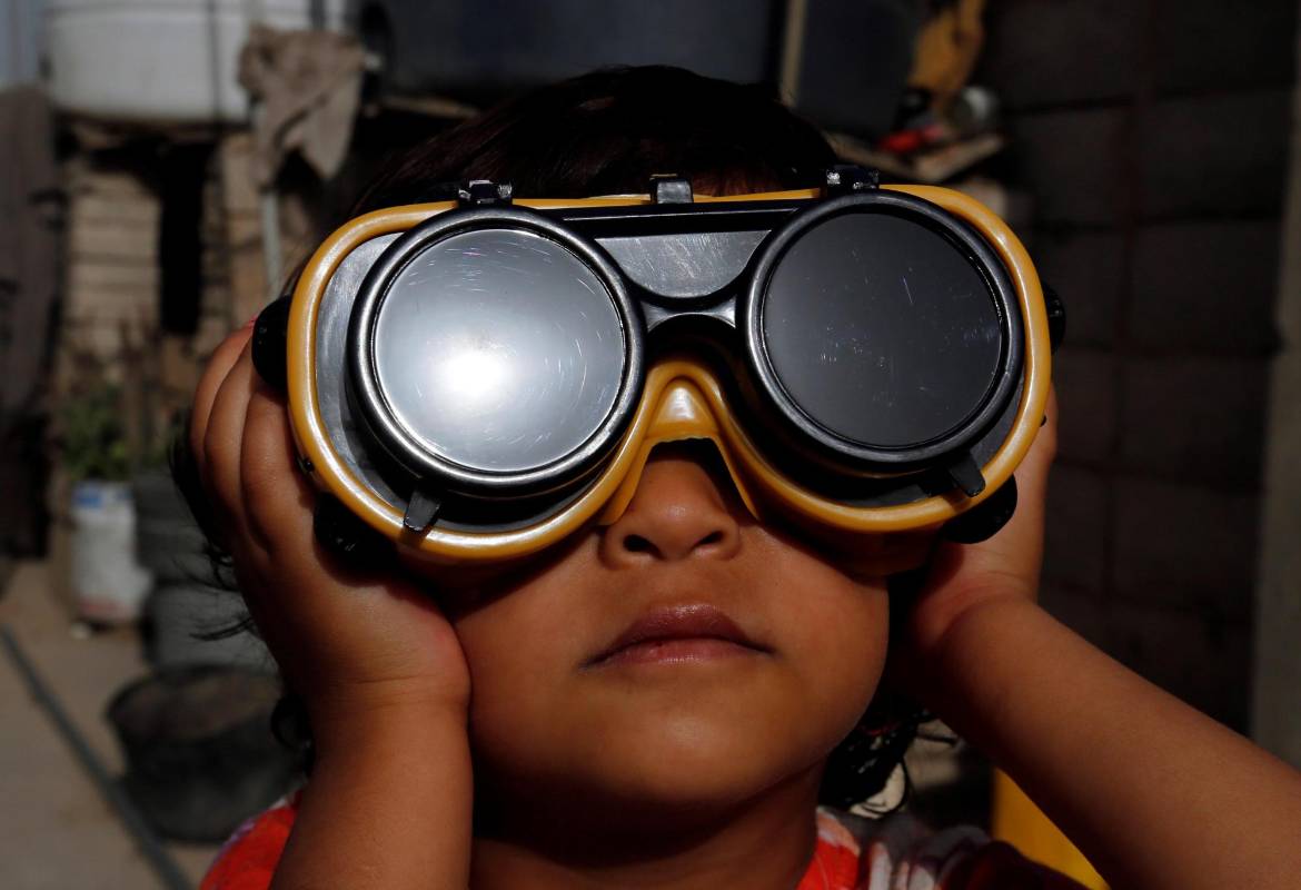 Un niño usa anteojos protectores especiales para observar un eclipse solar parcial en Sanaa, Yemen, 21 de junio de 2020. FOTO EFE