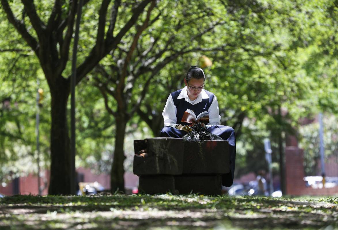 En medio de la agitada rutina de la ciudad, lectores espontáneos aprovechan un momento de calma para leer un buen libro. Foto: Manuel Saldarriaga.