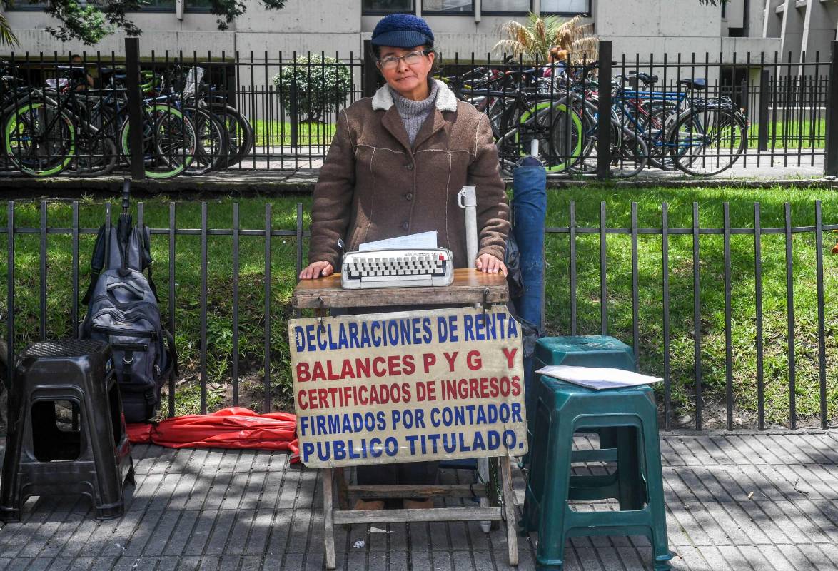 Candelaria Pinilla, empleada de la calle, experta en rellenar formularios como el impuesto a la propiedad, el impuesto sobre vehículos, el impuesto retenido en la fuente y la declaración del impuesto a la renta. Además, llevan a cabo derechos de petición, declaraciones juradas e incluso cartas. FOTO: LUIS ACOSTA; AFP.