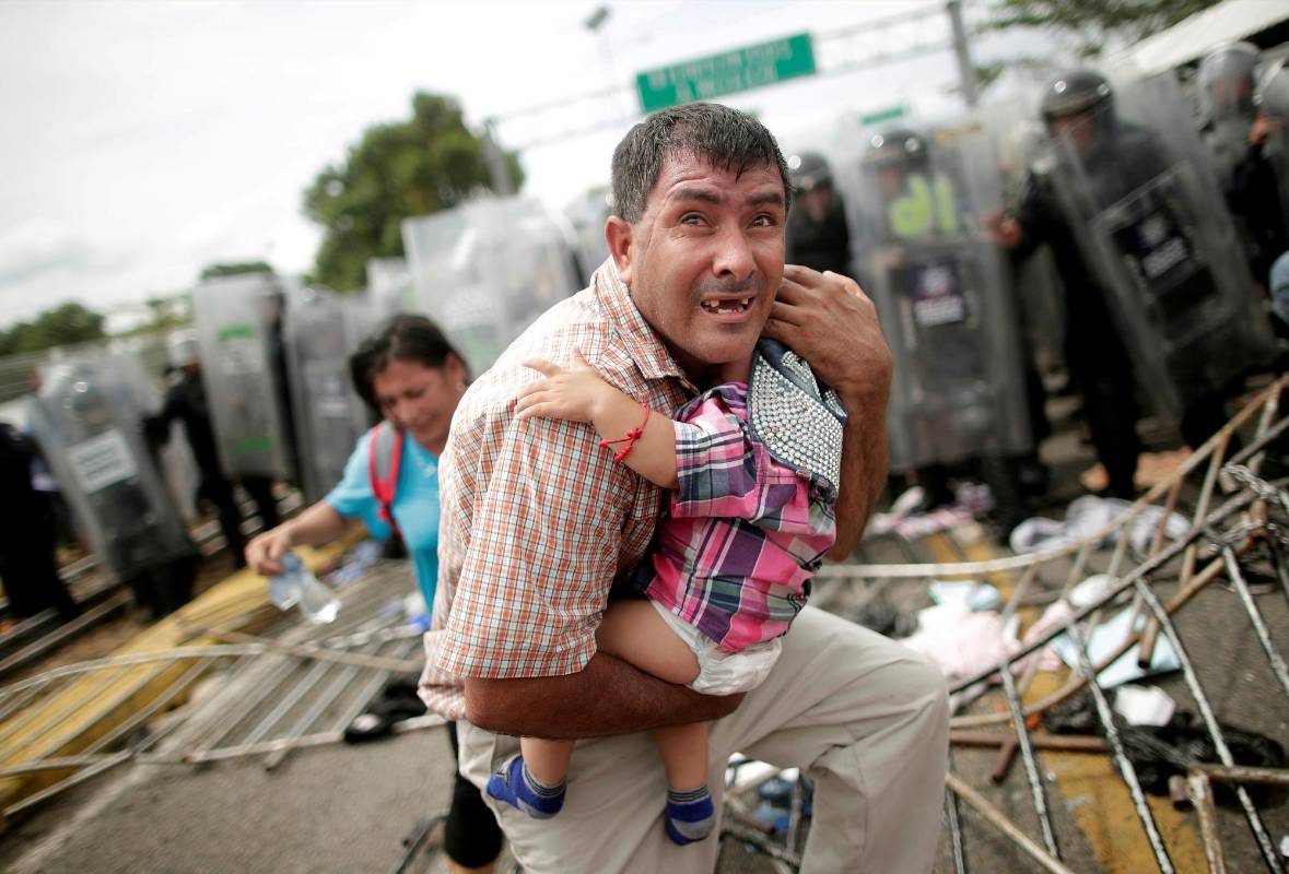 Un hondureño sostiene a su pequeño hijo, en Guatemala. Mayo. Foto: Reuters