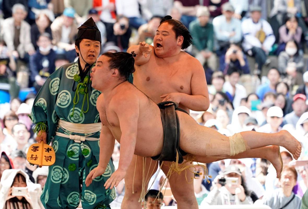  Dos luchadores de sumo realizan acrobacias durante una exhibición de “shokkiri” durante el “Honozumo”, un torneo ceremonial de sumo Foto: EFE/ Franck Robichon 