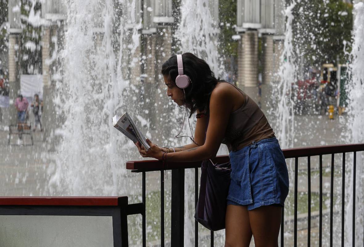 En medio de la agitada rutina de la ciudad, lectores espontáneos aprovechan un momento de calma para leer un buen libro. Foto: Manuel Saldarriaga.