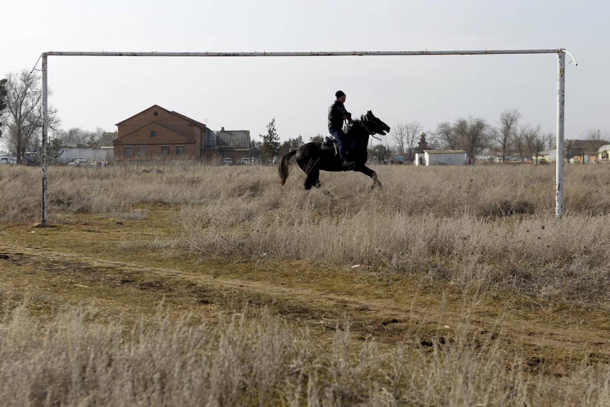 Un hombre monta un caballo cerca de un arco de fútbol en la aldea de Bolshaya Dzhalga en la región de Stavropol, Rusia. Foto: REUTERS / Eduard Korniyenko 