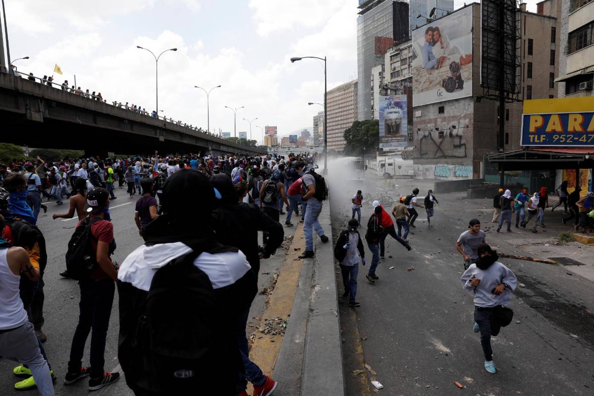 El canal en línea Vivo Play también mostró imágenes con decenas de manifestantes enfrentándose a los efectivos de la fuerza pública, usando piedras y regresando las bombas lacrimógenas. FOTO REUTERS