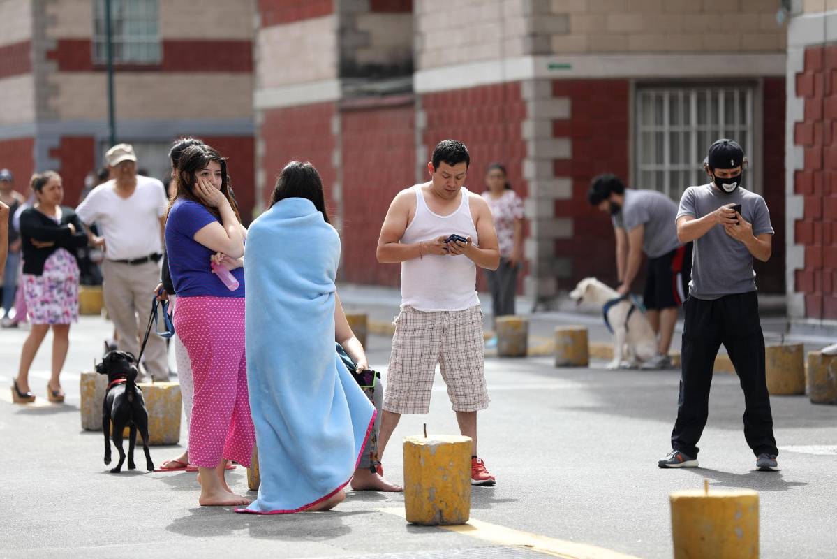 Con sus celulares, las personas intentaban comunicarse con sus allegados e informarse sobre los posibles daños que hubiera causado el fenómeno. FOTO EFE