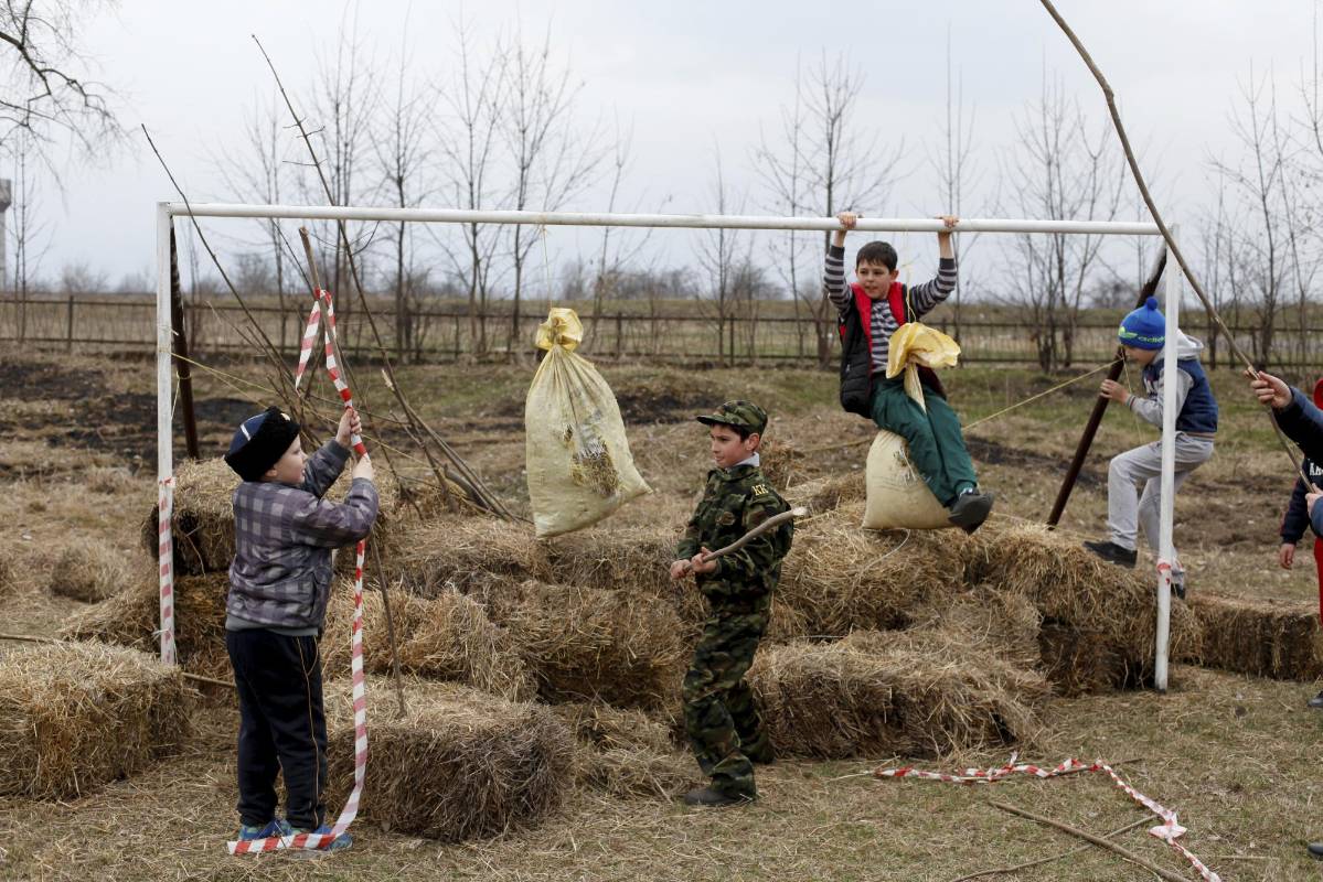 Niños juegan en un arco durante los juegos tradicionales cosacos fuera del pueblo de Arkhonskaya en la República de Osetia del Norte, Alania, Rusia. Foto: REUTERS / Eduard Korniyenko 