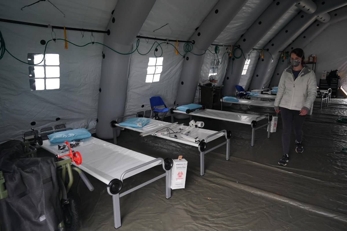 Las camas se alinean en una tienda de campaña mientras los voluntarios establecen un hospital de campaña de emergencia para los pacientes que sufren del coronavirus en Central Park, frente a la Quinta Avenida. Foto: AFP
